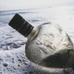 clear glass bottle on body of water Alcohol