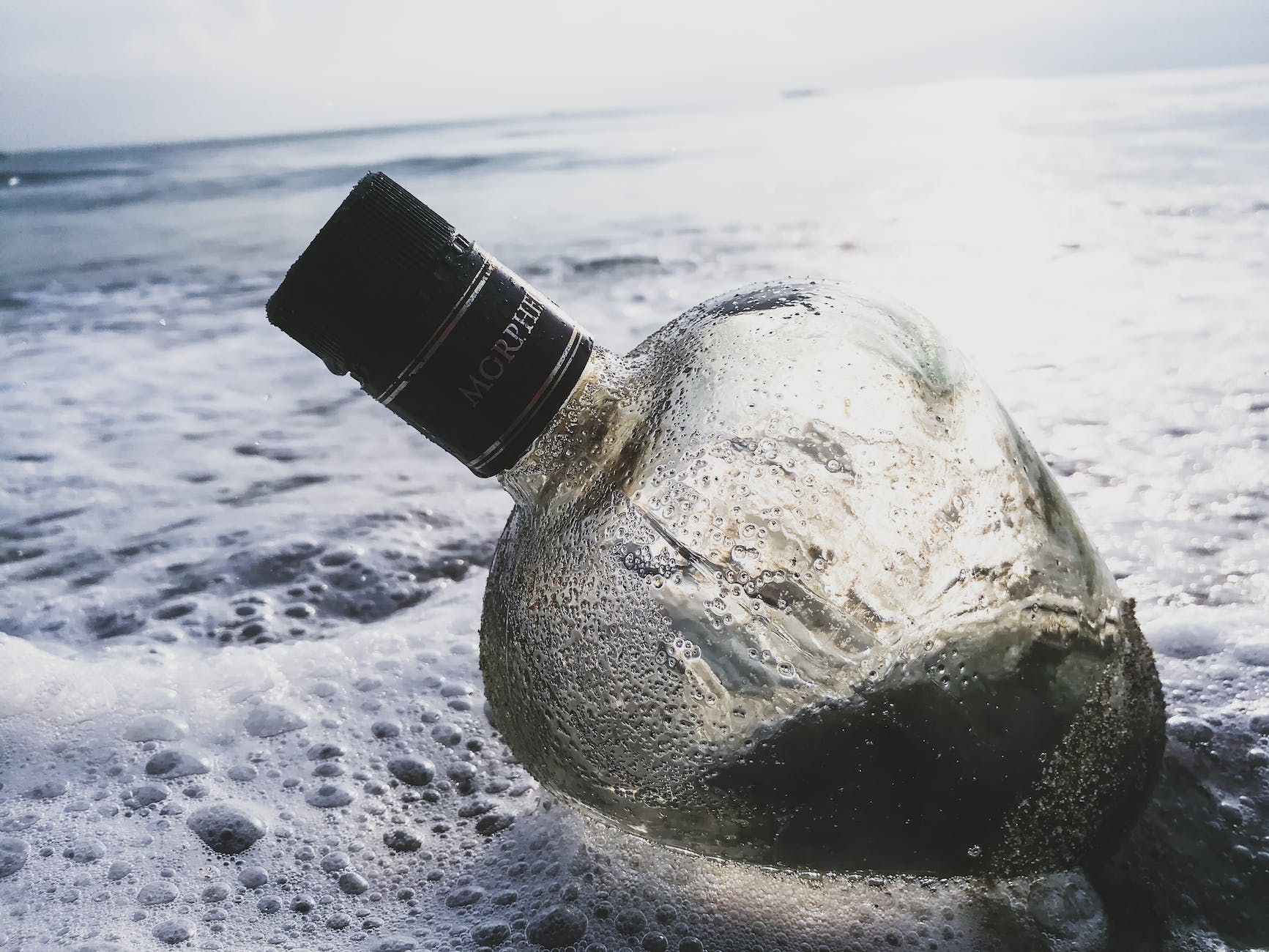 clear glass bottle on body of water Alcohol